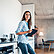 Woman standing and smiling in the kitchen with book or tablet, multi family house
